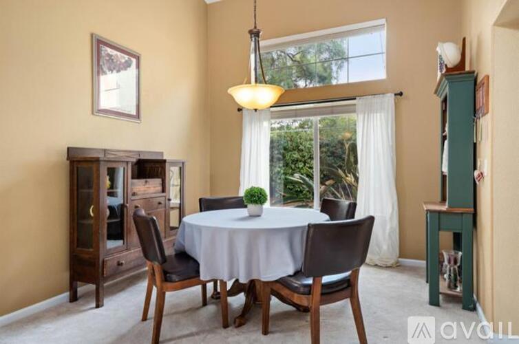 A dining room with a table set for four.