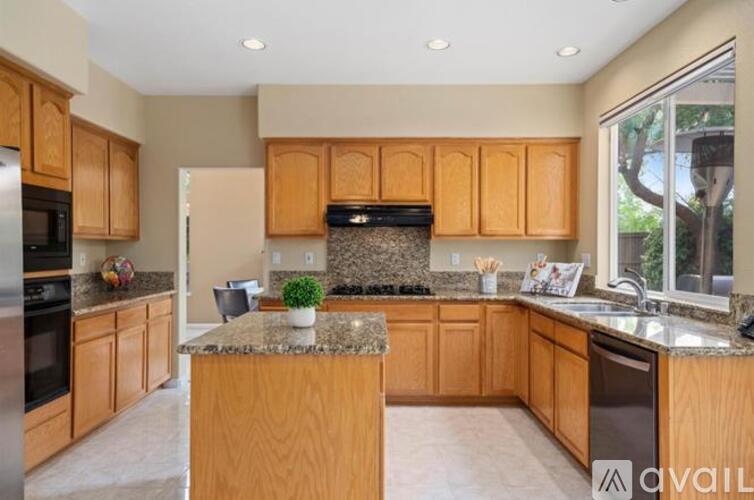 A kitchen with wooden cabinets and granite countertops.