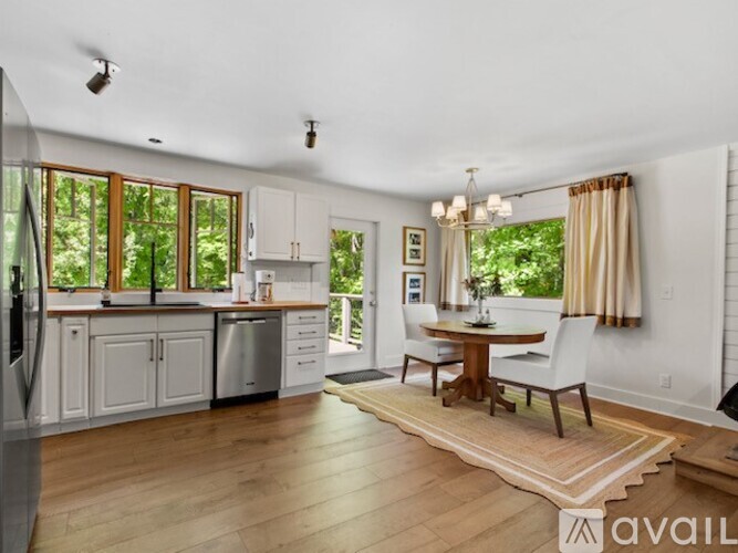 A kitchen with white cabinets and a wooden floor.