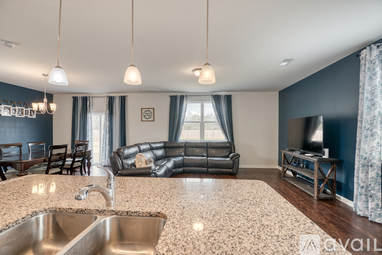 A kitchen with a sink and a sofa.