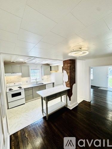 A kitchen with white cabinets and a brick wall.