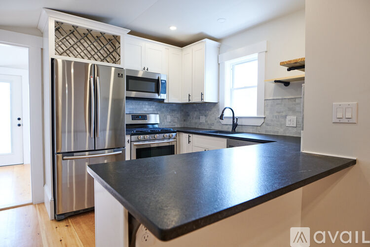 A kitchen with a black countertop and stainless steel appliances.