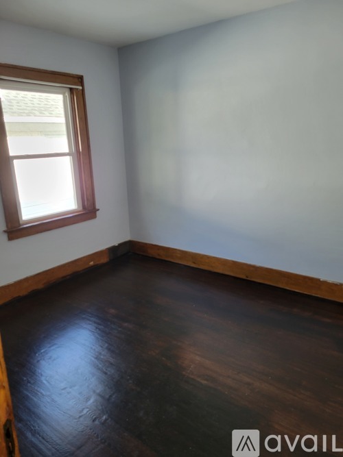 A room with a wooden floor and a window.