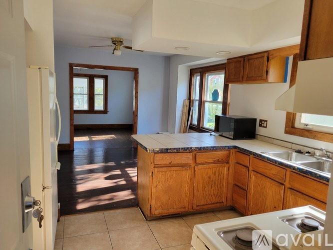 A kitchen with wooden cabinets and a white fridge.