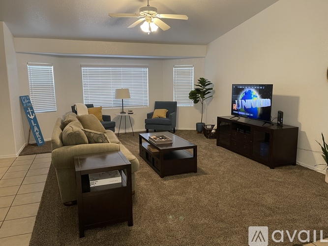 A living room with a couch, chair, and television.