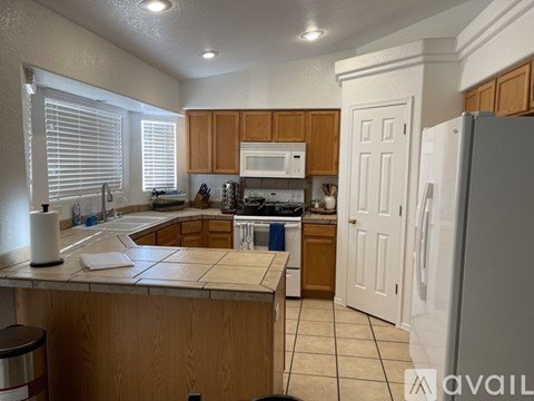 A kitchen with wooden cabinets and white appliances.