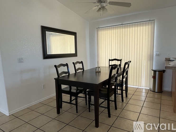 A dining room with a table and chairs.