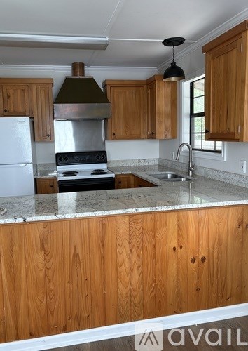 A kitchen with wooden cabinets and a marble countertop.