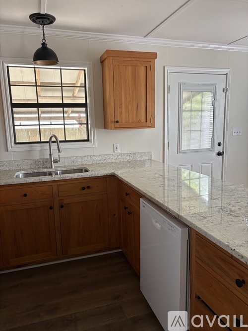 A kitchen with wooden cabinets and a white dishwasher.