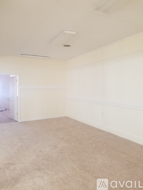 A room with white walls and carpeted floor.