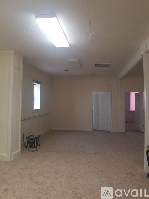 A room with a carpeted floor and a window.