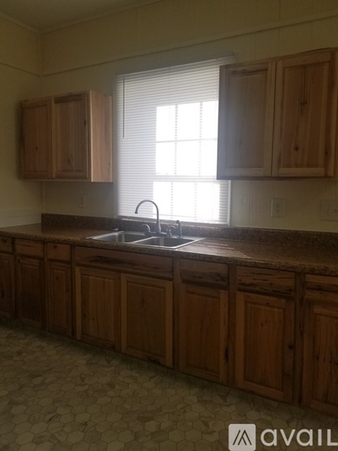 A kitchen with wooden cabinets and a tiled floor.