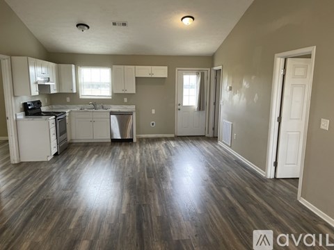 A kitchen with wood floors and white appliances is available.