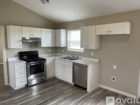 A kitchen with white cabinets and a black stove top oven.