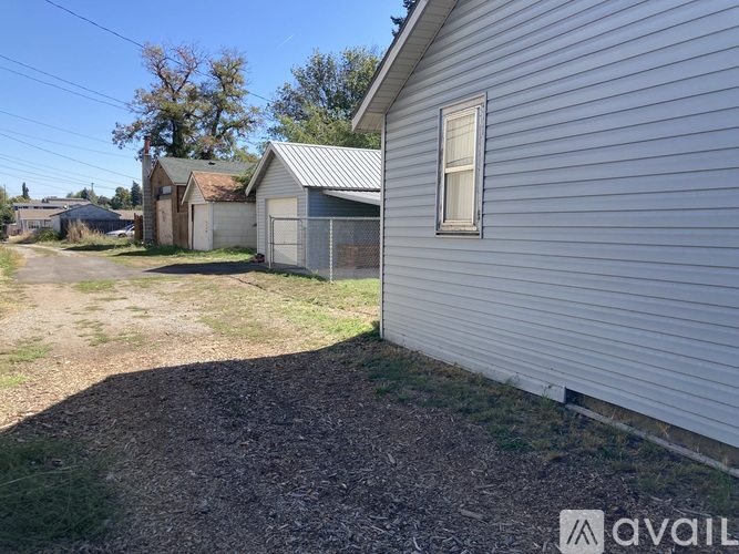 A gravel driveway leads to a garage and a house.