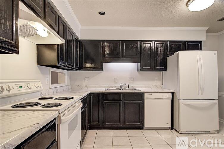 A kitchen with black cabinets and white appliances.