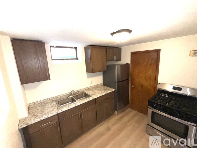 A kitchen with brown cabinets and a granite countertop.