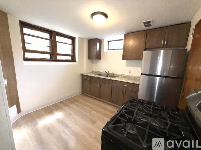 A kitchen with a stove, cabinets, and a window.