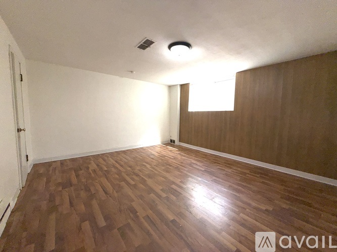 A room with wooden flooring and a window.