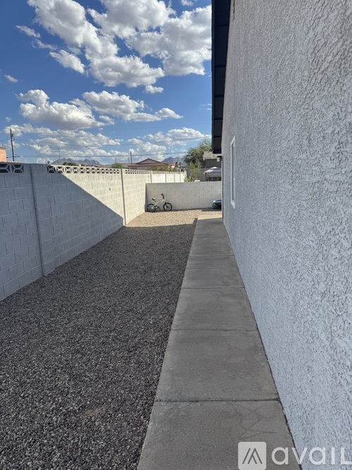 A concrete pathway leads to a white building.