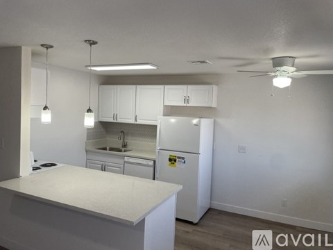 A kitchen with white appliances and cabinets.