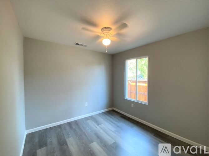 A room with a ceiling fan and a window.