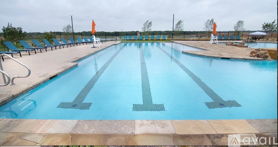 A large outdoor swimming pool with lanes marked on the water.