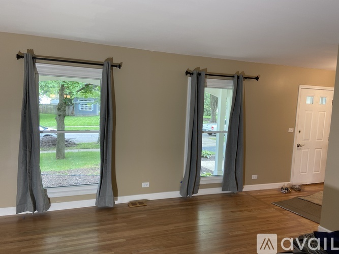 A room with wooden floors and grey curtains.