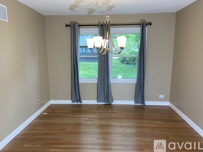 A room with wooden floors and a chandelier.