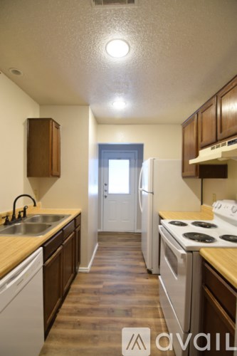 A kitchen with wooden cabinets and white appliances.