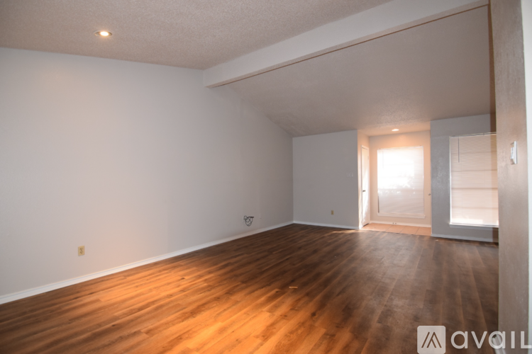 A room with wooden flooring and white walls.