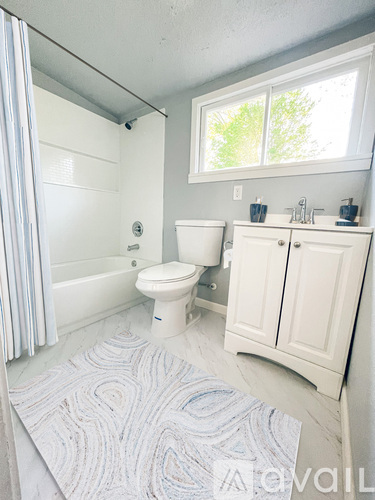A white bathroom with a toilet, sink, and bathtub.