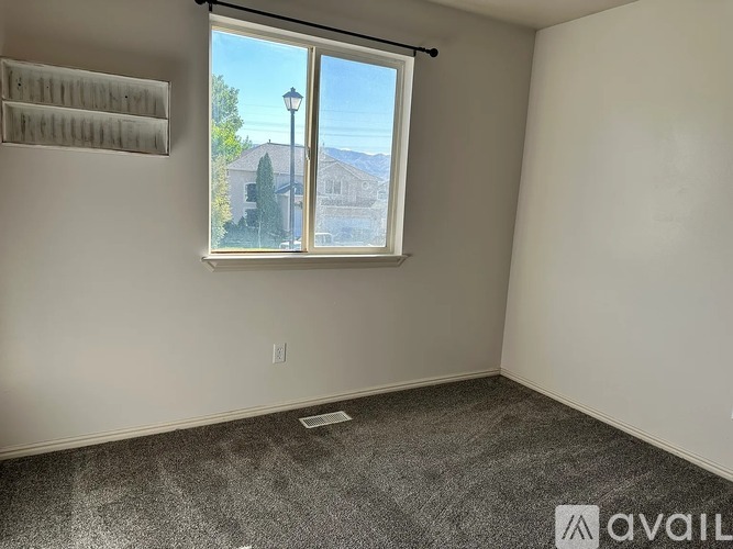A room with a window overlooking a street with a lamp post.