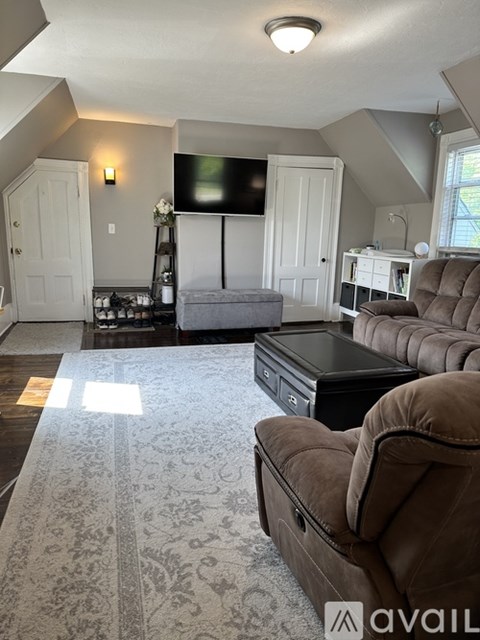 A living room with a brown couch and a black coffee table.
