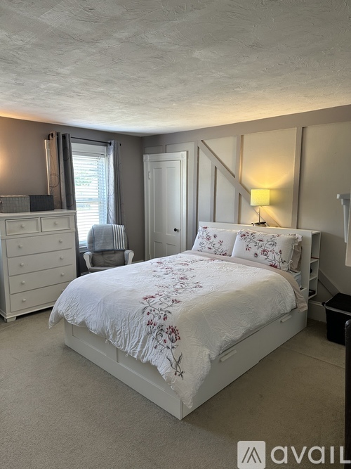 A bedroom with a large bed and a dresser.