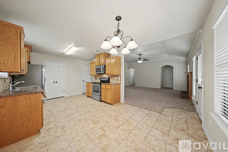 A kitchen with wooden cabinets and a tiled floor.