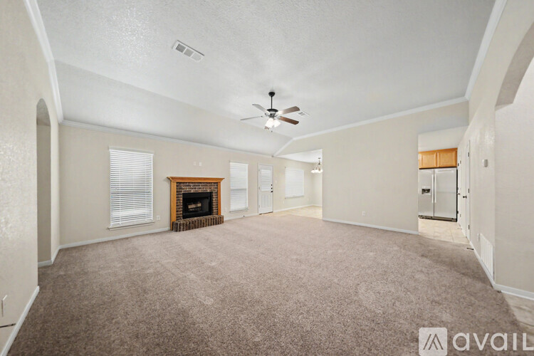 A spacious living room with a fireplace and a carpeted floor.