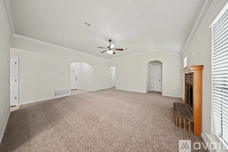 A spacious room with a ceiling fan and carpeted floor.