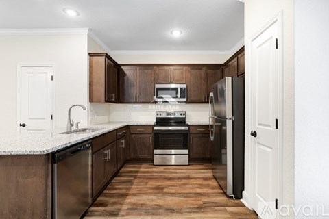 A kitchen with wooden cabinets and a refrigerator.