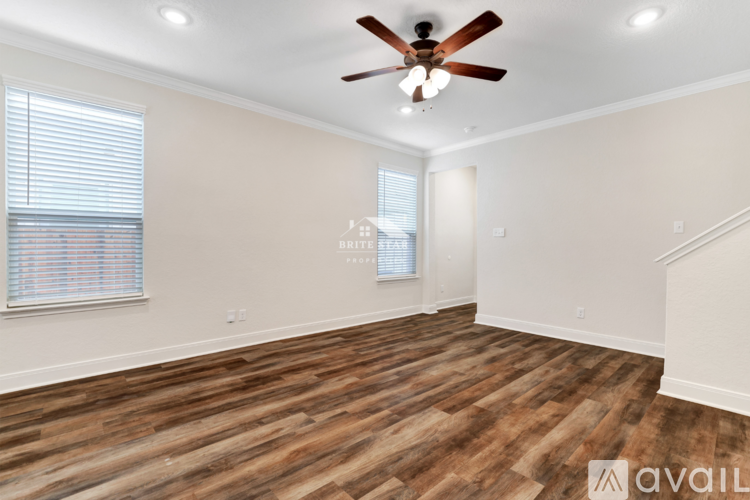 A room with wooden flooring and a ceiling fan.