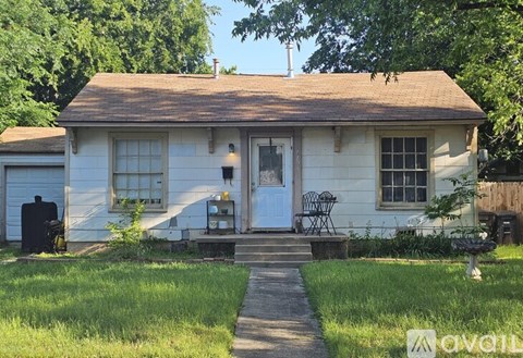 A small white house with a blue door and a porch.