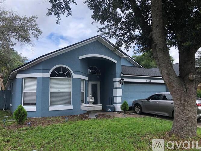 A blue house with a car parked in front.