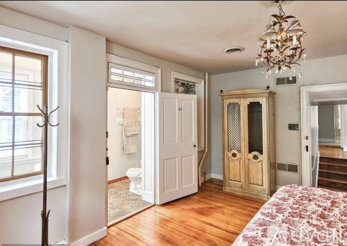 A bedroom with a large bed and a chandelier.