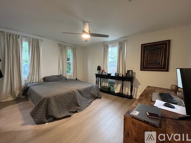 A bedroom with a large bed and a desk with a computer.