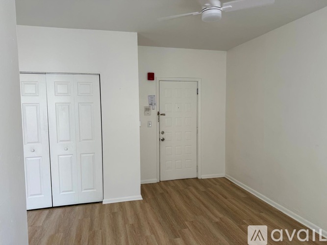A room with a white ceiling fan and two white doors.