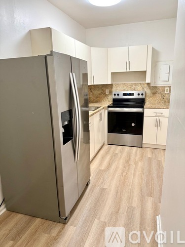 A kitchen with a stainless steel refrigerator and stove.