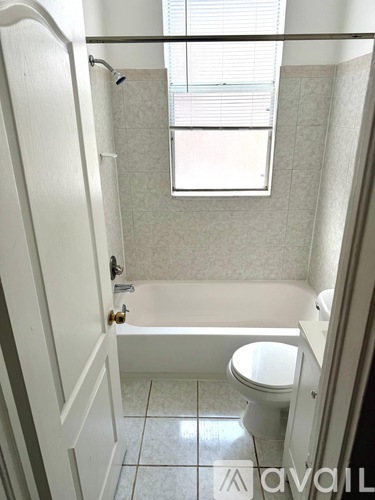 A bathroom with a toilet, tub, and shower.
