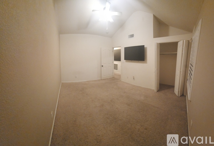 A spacious room with a flat screen TV mounted on the wall.