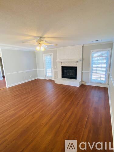 A room with a fireplace and wood flooring.