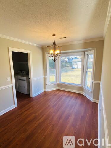 A room with wood floors and a chandelier.